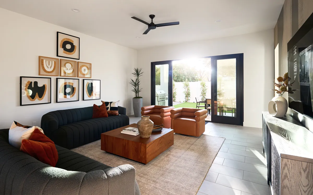 A welcoming interior living space with a textured dark sofa, wooden coffee table, large windows that open to the outdoors, and inviting natural light. The space is ideal for both casual meetings and team relaxation.